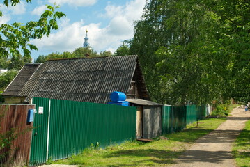 A rural street with a view of the bell tower on a summer day. Moscow region. Russia