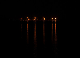 Fototapeta na wymiar ship lamp reflection in the water, reflection in night sea