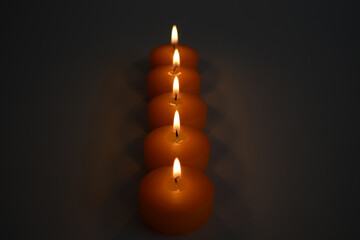 burning orange candles on a dark background