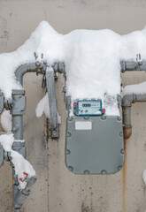 Snow covered natural gas line meter of building or home. High energy consumption in cold...