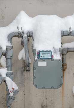 Snow covered natural gas line meter of building or home. High energy consumption in cold temperature.  Outdoor meter measuring the usage number in cubic feet. Vancouver, BC, Canada. Selective focus.