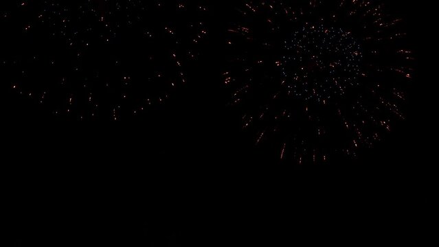 A black sky lights up with two giant fireworks explosions. 