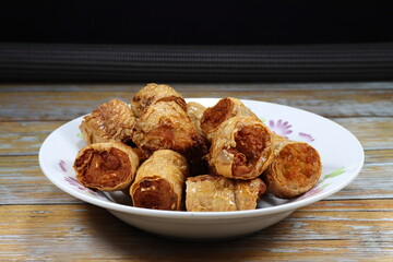 Pile of traditional deep fried tofu sheet wrapped crab meat serving on the plate. Famous crispy and crunchy starter dim-sum menu in Chinese restaurant. 