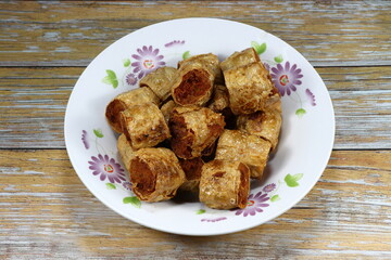 Pile of traditional deep fried tofu sheet wrapped crab meat serving on the plate. Famous crispy and crunchy starter dim-sum menu in Chinese restaurant. 
