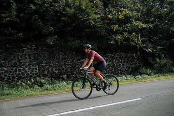 Fototapeta premium A young female cyclist riding her gravel bike in the mountains.