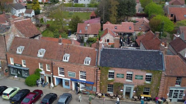 Sideways Slider Aerial Drone Shot of Beautiful Old Village Burnham Market Shops and Houses on Sunny and Cloudy Day North Norfolk UK