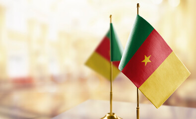 Small flags of the Cameroon on an abstract blurry background