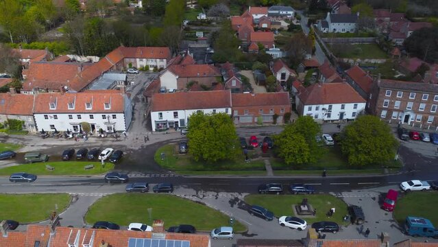 Sideways Aerial Drone Shot Flying Along Beautiful Old Burnham Market Village Main Street on Sunny and Cloudy Day in North Norfolk UK