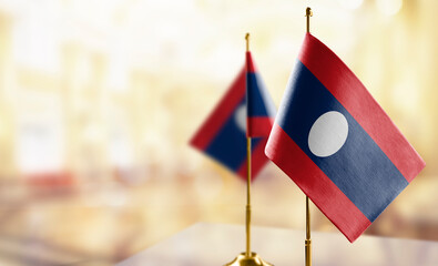 Small flags of the Laos on an abstract blurry background