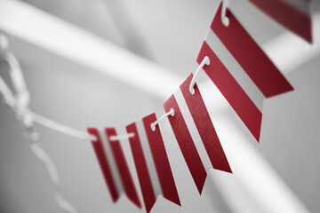 A garland of Latvia national flags on an abstract blurred background
