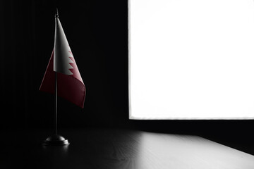 Small national flag of the Qatar on a black background
