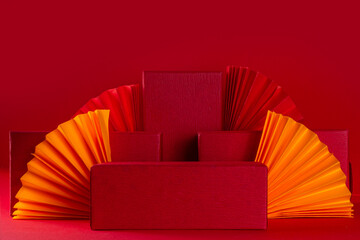 Chinese new year background, product pedestal podium display, with festive Chinese lanterns, paper fans and traditional New Year stripes posters for wishes on bright red background copy space