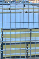 Obraz premium Metal fencing of a snow-covered court on a winter day