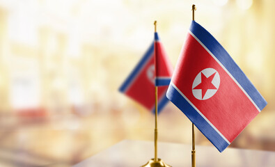 Small flags of the North Korea on an abstract blurry background