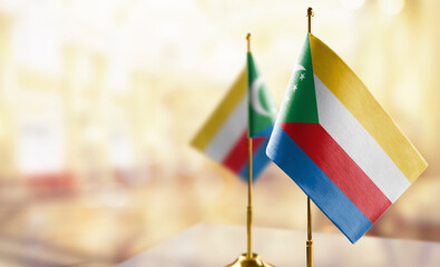 Small flags of the Comoros on an abstract blurry background