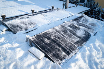 Solar panels on the roof are cleaned from snow with the broom