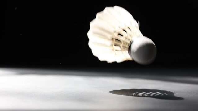 Slow motion of a Shuttlecock falling on a black background. Black background.