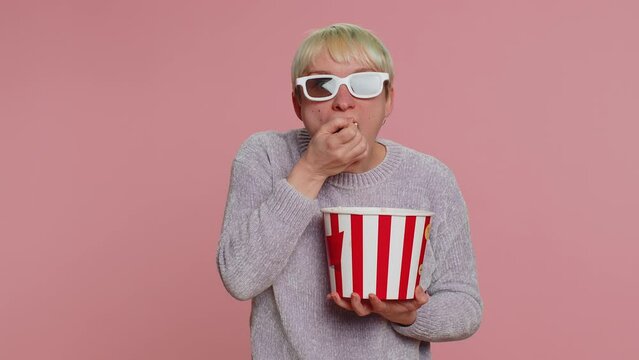 Excited Woman With Green Short Hair Eating Popcorn, Watching Tv Serial, Sport Game, Film, Online Social Media Movie Content. Young Girl In 3D Glasses Enjoying Domestic Entertainment On Pink Background