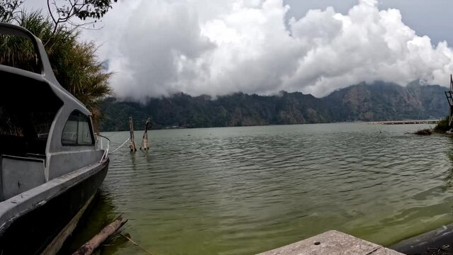 Time Lapse of boat on lake and white clouds moving fast in Kintamani, Bali