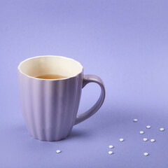 A cup of tea with sweetener.