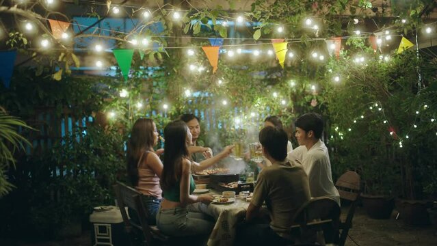 Asian people having a barbecue party and drinking beer.