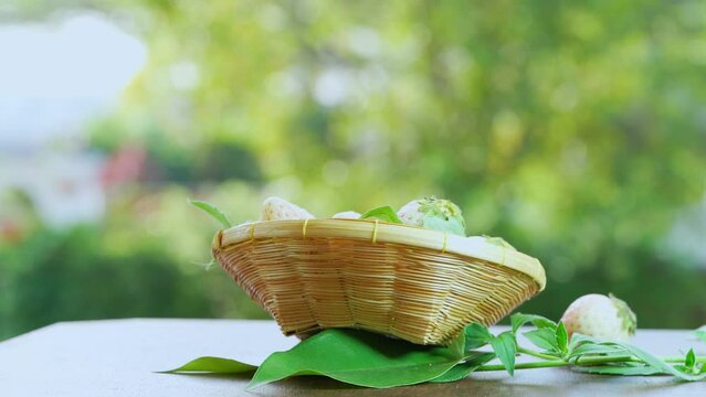 Pink snow strawberry in wooden basket on blurred greenery background, White and Pink snow Strawberries on wooden table in garden.