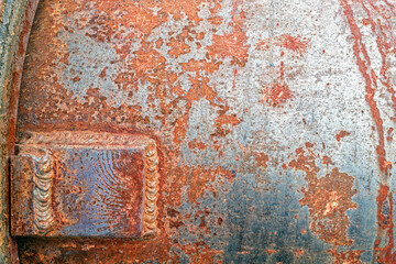 Welds on the rusty surface of a metal pipe at an abandoned mercury mine