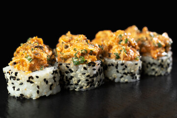 Sushi rolls set on a black background with reflection. Traditional Japanese food, angle view.