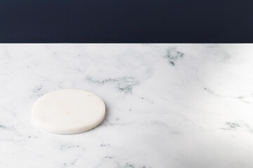 Mock up of white round little podium, pedestal. Minimal background for product presentation. Blank. Marble and Blue background.