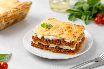 Homemade Italian lasagna. Delicious Lasagne with bolognese meat sauce and cheese on white plate. Recipe.