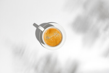 Hot coffee cup, mug of cappuccino, latte in hard light on white background with shadow, top view, flat lay. Mockup for design. Minimal style. Concept hot drinks, beverages.