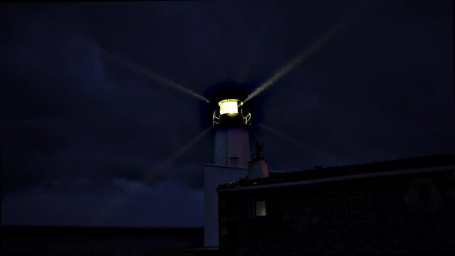 Lighthouse burning at dusk. Lighthouse light in rainy weather. Rotating lighthouse.