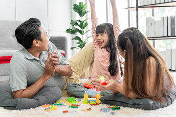 Asian family photo There are fathers, mothers and daughters. The father is the one holding the daughter. and having fun at home on the weekend