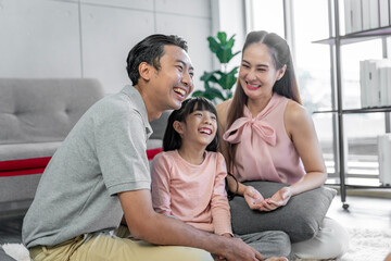 Fototapeta premium Asian family photo There are fathers, mothers and daughters. The father is the one holding the daughter. and having fun at home on the weekend