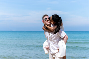 A couple of men and women of different nationalities go to the beach and walk happily on the beach together. on summer vacation