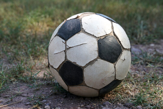 old soccer ball ,cracked leather but Thai rural students use it to play on the field during their breaks. Soft and selective focus.