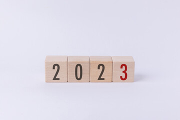 Wood cube block with 2023 text isolated in white background. New year goal, action plan, business...