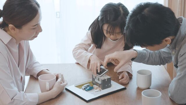 戸建の模型を見ながら話し合う家族
