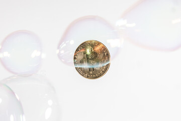One gold bitcoin token with white background and bubbles