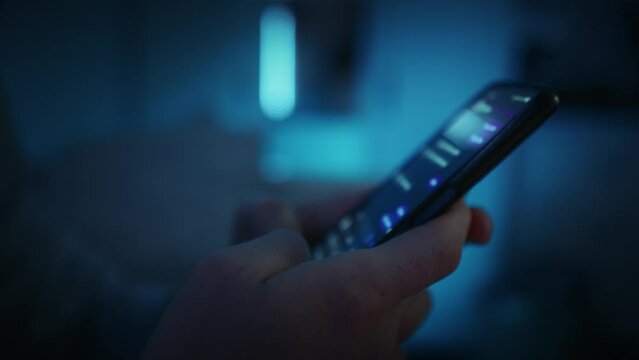 Detail of hands holding phone and texting at night. Shot with RED helium camera in 8K.   