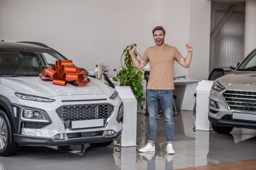 Happy and excited new car owner in a car salon