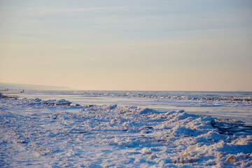 Fototapeta na wymiar Winter landscape with icy sea coast and calm blue sky, selective focus