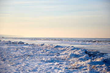 Fototapeta na wymiar Winter landscape with icy sea coast and calm blue sky, selective focus