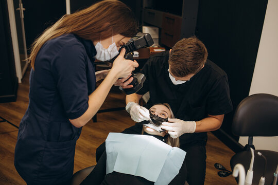 Woman dentist taking pictures of teeth before teeth whitening procedure. Dental and teeth whitening