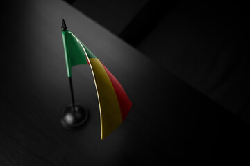 Small national flag of the Benin on a black background