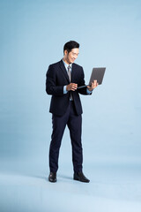 portrait of asian businessman wearing suit on blue background