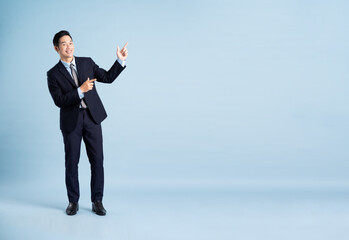 portrait of asian businessman wearing suit on blue background