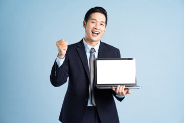 portrait of asian businessman wearing suit on blue background