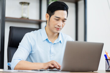 Fototapeta premium Asian businessman male portrait sitting at his desk
