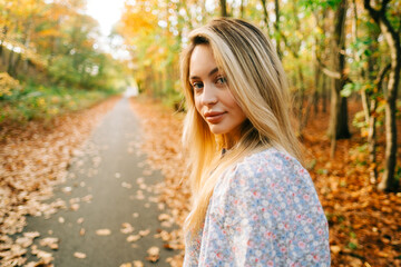 Portrait of attractive caucasian woman posing in the autumn park.